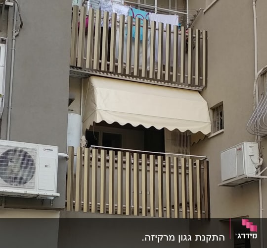 סוכך בד בהיר על מרפסת עם מעקה עץ